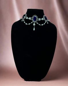 Handcrafted replica period jewelry, made to imitate the style and grandeur of the Tudors. This elegant necklace will complement any renaissance garb, and elevate even the most simple gown into a piece fit for a queen. It is made to order in your choice of gold, silver, or bronze and can be set with resin gemstones of just about any color. Ruby, emerald, sapphire, amethyst and onyx are most popular options.The Marguerite de Navarre features a row of gemstone settings connected with a double line of pearl bead sections. Beautiful swags of metal capped pearls also hang across the bottom. A large pearl and teardrop combo set off the center of the necklace. Gemstone Settings, Tudor Gown, Simple Gown, Period Jewelry, The Tudors, Simple Gowns, Tudor Style, Ruby Emerald, Elegant Necklace