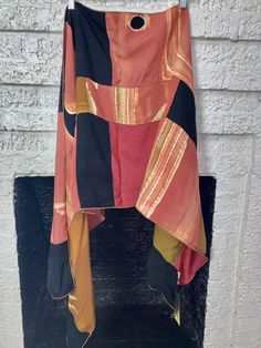 an orange and black dress hanging on a brick wall