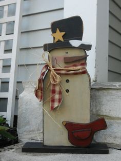 a wooden snowman with a hat and scarf