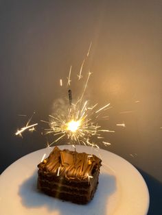 a piece of cake on a white plate with sparklers