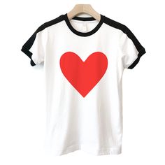 Love is in the air all year around - not just during Valentine's Day. These t-shirts are old school looking and retro in style with black stripes that runs down the shoulders, plus black stripe hems along the crew neck and base of the sleeves. Shirts are hand printed by Christy (me perfectly unisex in fit and style, plus 100% cotton. Also available in toddler and youth sizes in the same printed ink color and t-shirt style, plus cute baby one pieces are well :) ▼▼ click link for MORE HEART PRODUC Casual Red T-shirt With Heart Graphic, Retro Cotton T-shirt With Heart Graphic, Cotton Heart Print T-shirt For Streetwear, Black Heart-shaped Casual T-shirt, Black Casual Heart-shaped T-shirt, Casual Black Heart-shaped T-shirt, Casual Black T-shirt With Heart Shape, Black Crew Neck T-shirt With Heart Print, Sporty Cotton Top With Heart Graphic