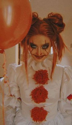 a woman with red hair and makeup is holding balloons in her hand while wearing a white dress