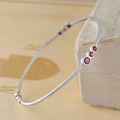 Silver Cellular Ruby And Garnet Bangle - This handmade intricate bracelet bangle with hand-set precious ruby and garnet gem stones is made from sterling silver with an textured organic feel. #Embersjewellery #Jewellery #Valentine #Valentinesday #PersonalisedGift #ForHer Red Stone Bracelet, Small Earrings Gold, Silver Ruby Ring, Ruby Bangles, Handmade Silver Jewellery, Garnet Gem, The Bangles, Gemstone Bangle