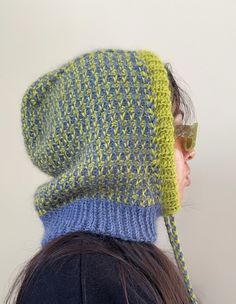 a woman wearing a knitted hat with two different colors on the top and bottom