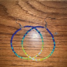 three beaded bracelets sitting on top of a wooden table