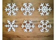 six snowflakes are arranged on a wooden surface