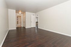 an empty room with hard wood floors and white walls