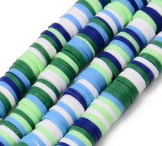 multicolored glass beads are lined up on a white surface with blue, green and white stripes