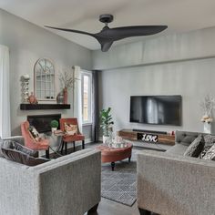 a living room filled with furniture and a flat screen tv mounted on the wall above a fireplace