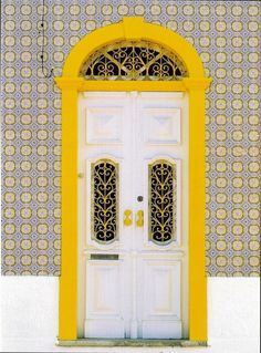 a white door with yellow trim and an arch over the top that says portugal