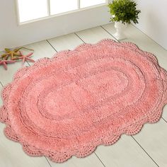 a pink rug is on the floor next to a potted plant and starfish