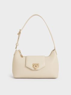 The Arwen makes its return in a classic baguette bag style but with a slouchier silhouette. You will have plenty of room for your everyday essentials and more. Crafted with a push-lock closure flap opening, the polished gold accent adds a glimmer of shine that stands out from the beautiful beige finish -- this piece is an embodiment of minimalist style. Use it as an on-the-go shoulder bag or adjust the strap for a casual crossbody look. Cream Shoulder Bag, White Leather Shoulder Bag, Purses 2024, Beige Bags, Charles And Keith Bags, Purse Aesthetic, Minimalist Bags, Beige Shoulder Bag, Beige Purse