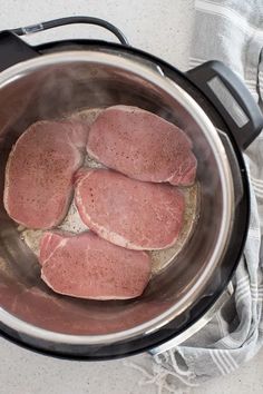 raw meat cooking in an instant pot on top of a towel next to a stove