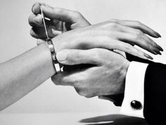 black and white photograph of two hands holding each other's fingers with one hand