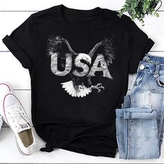 Introducing our Eagle USA Tee, where national pride and majestic wildlife come together in a bold and striking design. This black t-shirt features an illustration of a flying bald eagle and the letters "USA," capturing the spirit of freedom, strength, and patriotism. Perfect for those who love to showcase their American pride in a unique and powerful way. Crafted with meticulous attention to detail, our Eagle USA Tee offers both style and comfort. Made from premium, soft, and breathable fabric, Eagle Graphic Tee, Eagle Graphic, Usa Tee, Usa Shirt, American Pride, Cozy Fits, American Shirts, Bald Eagle, Fourth Of July