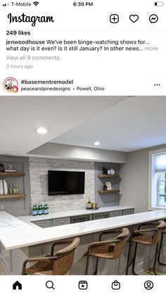 an instagramted photo of a kitchen with bar stools and a tv on the wall