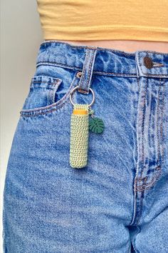 a person wearing blue jeans with a banana keychain attached to the back of their pants