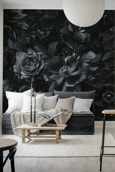 a living room with black and white flowers on the wall, couches and tables