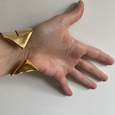 A lighter cuff on the repertoire. I have created this piece out of a single sheet of metal. It is completely formed and can be worn showing the ends on the front or the wide strip on the front. ~1.5" wide ~fabricated out of a single brass sheet and finished in 14k nickel free gold plating Bracelet is light and can be adjusted to fit the wrist. Slip on gently due to the ends but adjust by softly squeezing to fit around your wrist a little less loosley. Bold, unique and sculptural jewelry, handmad Gold Polished Cuff Bracelet, Modern Yellow Gold Metal Cuff Bracelet, Formal Yellow Gold Brass Cuff Bracelet, Unique Cuff Bracelet For Formal Occasions, Luxury Brass Bangle Cuff Bracelet, Gold Polished Open Cuff Bracelet, Minimalist Metal Cuff Bracelet, Minimalist Gold Metal Cuff Bracelet, Gold Cuff Bracelet With Polished Finish