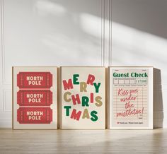 three christmas cards are on the floor in front of a white wall and wooden floors