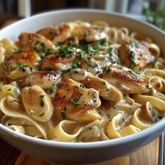 a white bowl filled with pasta and chicken