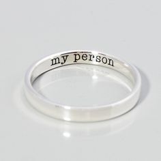 a silver ring with the words my person engraved on it's side, sitting on a white surface