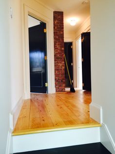 an empty room with hard wood floors and black doors