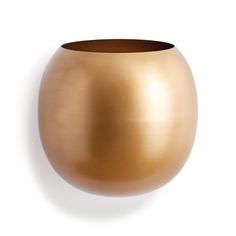 a gold vase sitting on top of a white wall