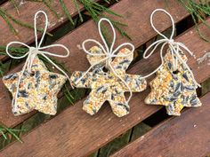 three pieces of bird seed sit on top of a wooden bench, tied with twine