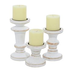 three white candles are sitting on top of each other