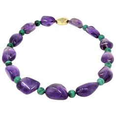 A modern circa 1980 beaded necklace by the Italian designer Tambetti featuring large nugget shape of natural amethysts alternated with round malachite beads. The clasp is designed to compliment the irregular shape of the amethysts, it is made in 18 karat polished yellow gold. The necklace weighs 188 grams and 21 inches long. Beading Necklace, Bead Creations, Miriam Haskell Jewelry, Natural Gemstone Necklace, Violet Color, Miriam Haskell, Bridal Jewellery Indian, Amethyst Jewelry, Italian Designer