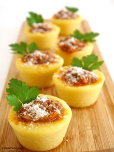 several small pastries with sauce and parmesan on a cutting board, ready to be eaten