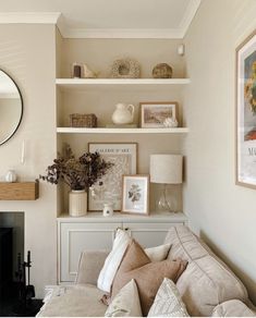 a living room filled with furniture and a fire place next to a wall mounted mirror