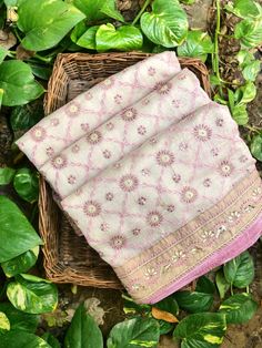 three pieces of cloth sitting on top of a basket next to some leaves and plants