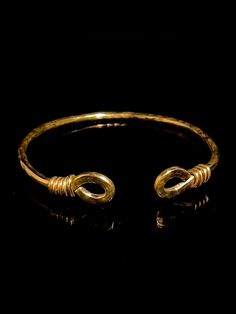 a gold bracelet with two rings on it