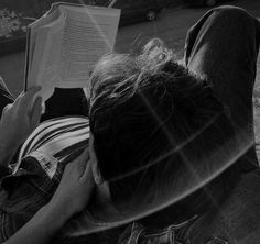 two people sitting on the ground reading books