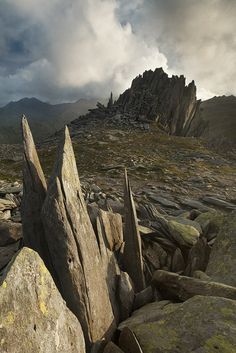 large rocks and boulders on the ground with mountains in the backgrouds behind them