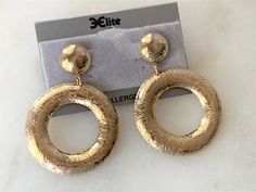 "Polished Gold Tone Floral Engraved Front Hoop Drop Pierced Earrings Hoops are Slightly Domed Earrings Measure 2 1/2\" Long x 1 3/4\" in Diameter The Round Tops are Hollow Domed and Measure 5/8\" in Diameter These Earrings are Very Light Weight Surgical Steel Hypo Allergenic Posts Gold Tone Backs Made in USA COMPLIMENTARY DOMESTIC SHIPPING" Earrings Hoops, Faceted Crystal, Pierced Earrings, Chain Link Necklace, Box Chain, Earring Backs, Earings Piercings, Spring Rings, Stones And Crystals