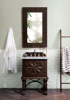 a bathroom sink sitting under a mirror next to a towel rack