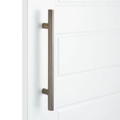 an open door with a metal handle on it's left side and white walls in the background