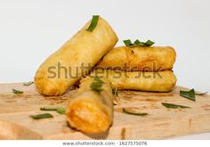 three fried food items on a cutting board with parsley and seasoning sprigs