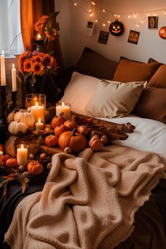 a bed with candles and pumpkins on it