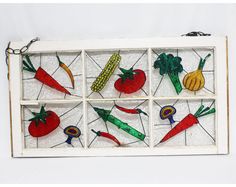 an old window with stained glass and vegetables on the windowsill, hanging from a chain