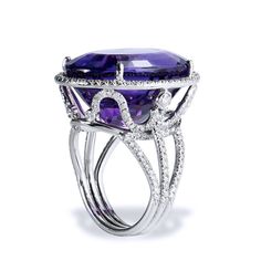 Crafted in 18kt white gold, this ring features a 22.70ct Amethyst center gemstone. The Amethyst is showcased in a beautifully ornate setting that features .75ct of H-VS graded pave set diamonds. SKU: 07287 Luxury Platinum Amethyst Ring In Silver, Luxury Tanzanite Diamond Ring For Formal Occasions, Luxury Purple Diamond Ring For Formal Occasions, Luxury Purple Platinum Rings, Luxury Amethyst Ring With Prong Setting, Formal Purple Diamond Ring With Gemstone Accents, Exquisite Amethyst Ring With Gemstone Accents For Formal Occasions, Luxury White Gold Amethyst Ring With Gemstone Accents, Luxury White Gold Amethyst Ring With Diamond