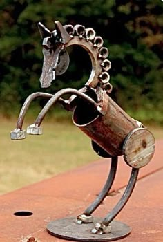 a metal horse head on top of a piece of wood