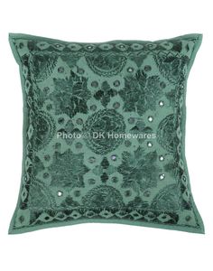 an embroidered pillow with sequins and beads on the front, in shades of green