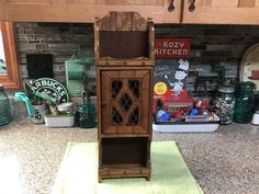 a wooden cabinet sitting on top of a kitchen counter next to a green place mat