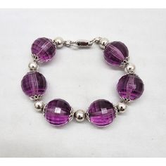 Early 1960s rhodium plated faceted purple resin beads with filigree detail terminals and round rhodium plated bead spacers and fold over clasp. Marked "NAPIER." Measures: 8 1/2 inches long by 3/4 inches wide. Interior circumference due to the thickness of the beads is about 7 1/4 inches. Excellent condition. Elegant Nickel-free Crystal Bracelet With Round Beads, Elegant Nickel-free Purple Bracelets, Elegant Nickel Free Purple Bracelets, Elegant Purple Beaded Bracelets With Silver Beads, Nickel-free Round Bead Bracelets For Party, Formal Metal Bracelets With Round Beads, Metal Crystal Bracelet With Faceted Beads, Adjustable Purple Jewelry With Silver Beads, Round Party Bracelets With Faceted Beads