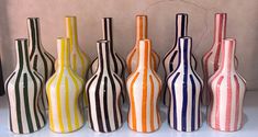 seven colorful striped vases lined up in a row