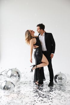 a man and woman are standing in the water with bubbles all around them, posing for a photo